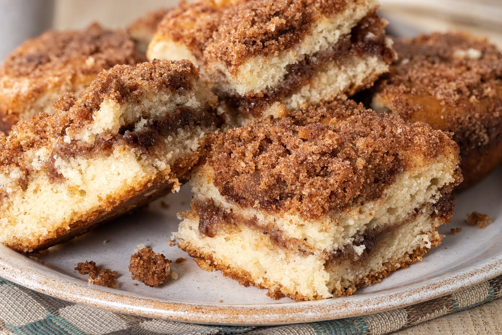 Closeup of a pile of sliced cinnamon streusel coffee cake on a plate.