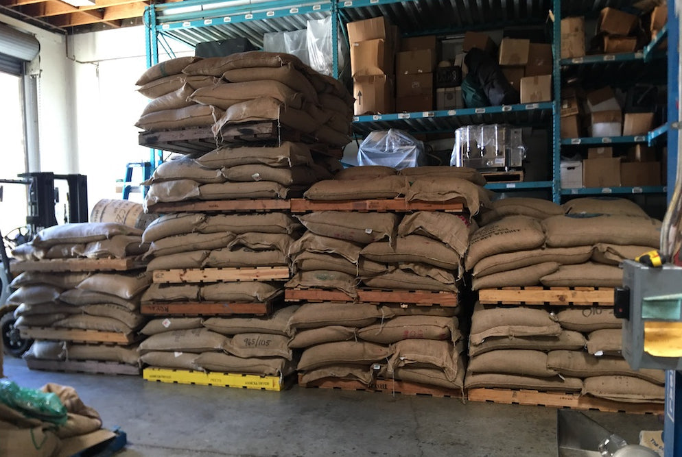 Coffee Bags stacked on wooden pallets on Coffee Roastery Floor.