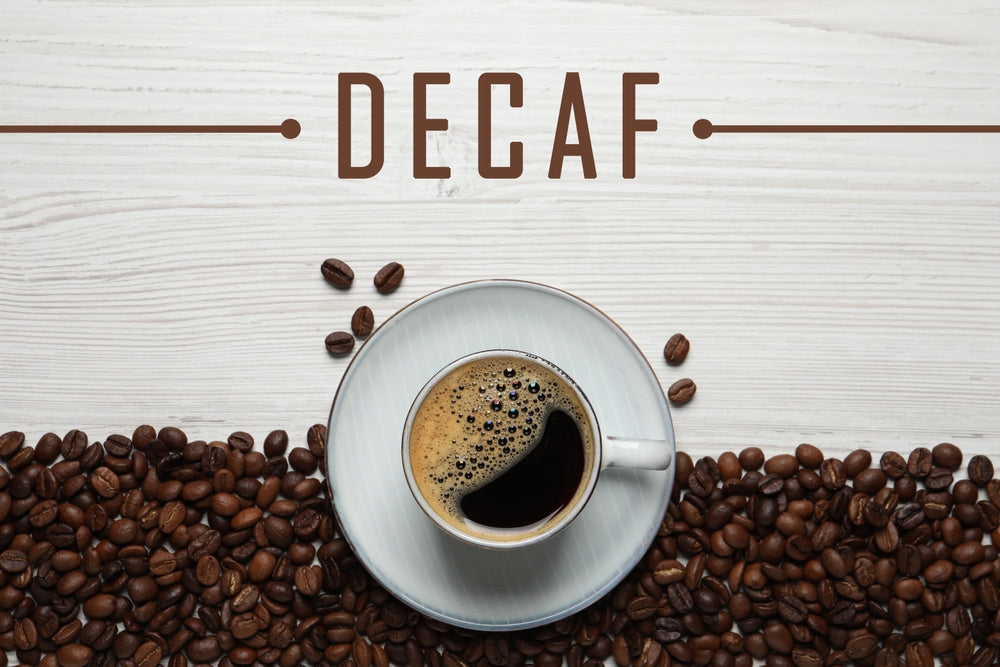Cup of aromatic decaf coffee and beans on white wooden table and lay flat.