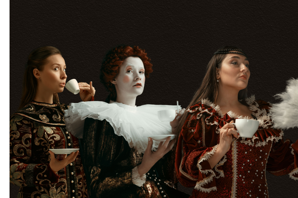 Three women in Medieval Dress drink coffee.