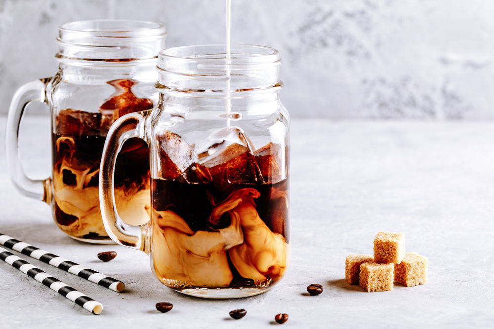 Two Mason Jar, filled with Cold Brew Coffee and coffee ice cubes.