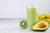 Avocado smoothie on a gray background. Green smoothie with avocado, kiwi, and banana.