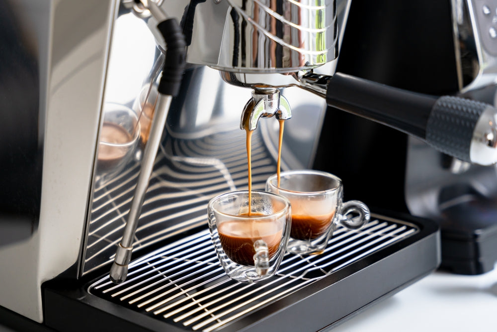 Brewing espresso in to glass cups silver coffee espresso machine.