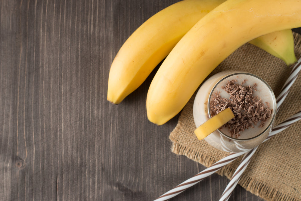 Chocolate Banana Smoothie on a wooden table with coffee and spices.