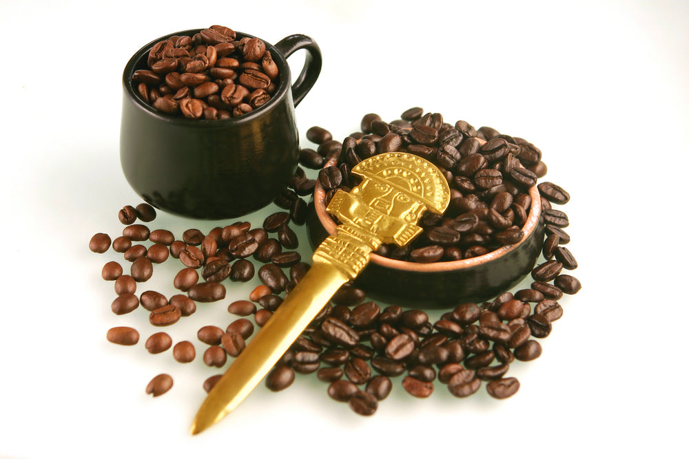 Coffee beans of two kind in a little brown cup and saucer with gold ritual knife from Peru.