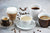 Different coffee drink types in different cups. Espresso, cappuccino, Americano, latte are presented. Coffee beans on the surface of a light table.