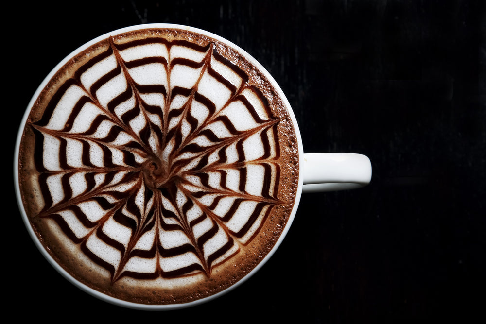 Hot coffee latte in white cup decorated on black background, latte art.