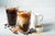 Iced Vietnamese coffee in a tall glass with cream poured over and coffee beans.