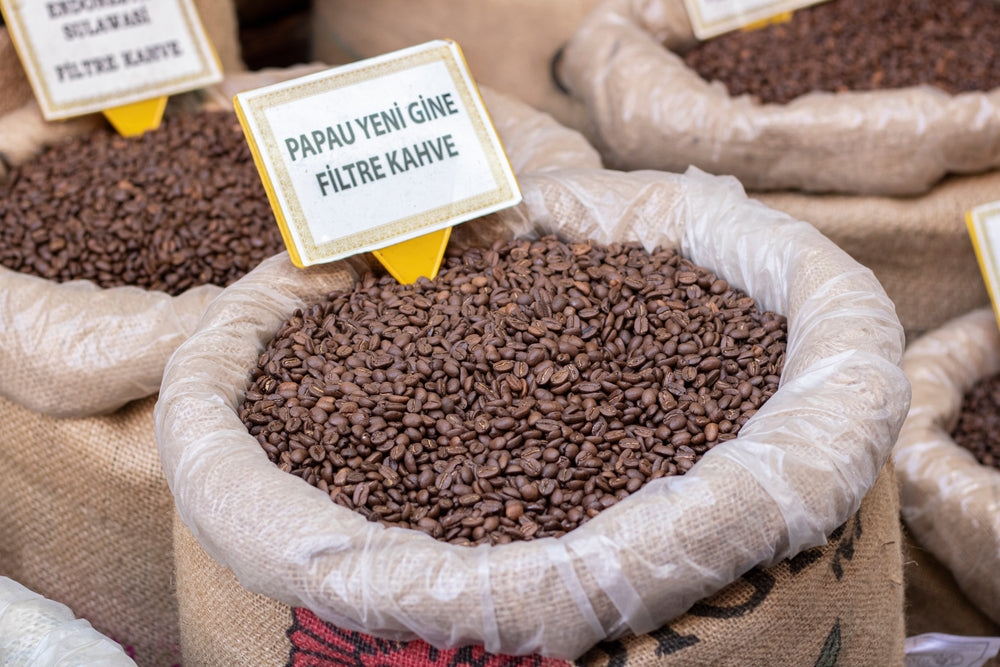 Papua New Guinea Roasted coffee beans in burlap sacks close up.