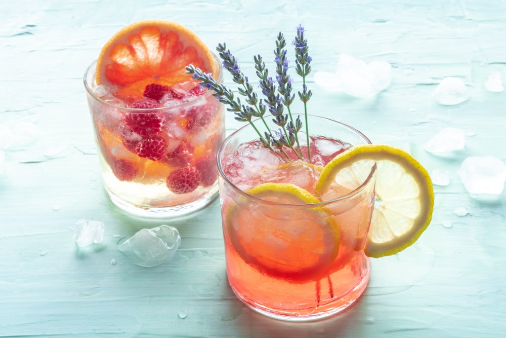 Tea mocktails, cold drinks with fruits and lavender on a blue background.