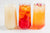 Three herbal tea mocktails in a tall glass with ice on a white background.