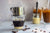 Vietnamese coffee with condensed milk in glass cups with traditional metal coffee maker phin on white table.