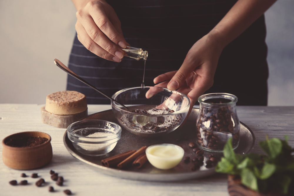 Woman making coffee body scrub on wooden table.