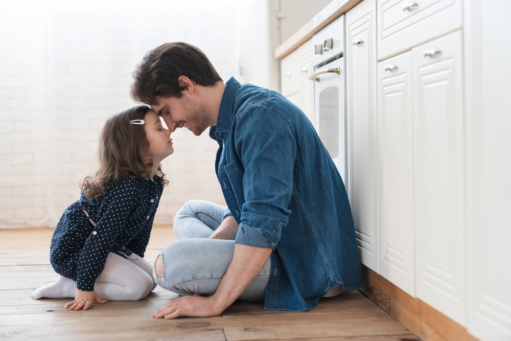 Young father and little daughter spending time together, playing on the floor.